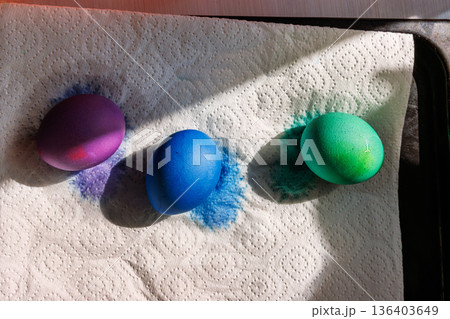 Colored easter eggs drying on paper towel in sunlight. Close up 136403649