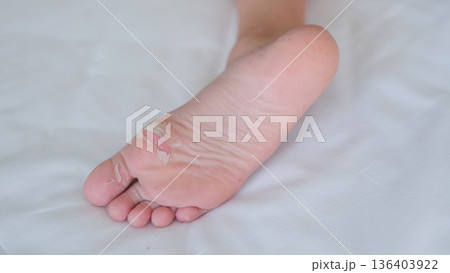 Healing skin and gentle textures on a bare foot resting softly on a white sheet 136403922