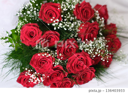 Vibrant red roses bloom beautifully, nestled among delicate baby s breath in a charming floral arrangement celebrating love and joy Vibrant red roses bloom beautifully, nestled among delicate baby s breath in a charming floral arrangement celebrating love and joy 136403933