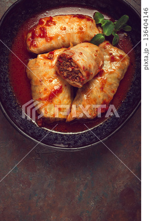 Stuffed cabbage rolls with minced meat, in tomato sauce, top view, without people, in the spotlight. Stuffed cabbage rolls with minced meat, in tomato sauce, top view, without people, in the spotlight. 136404146