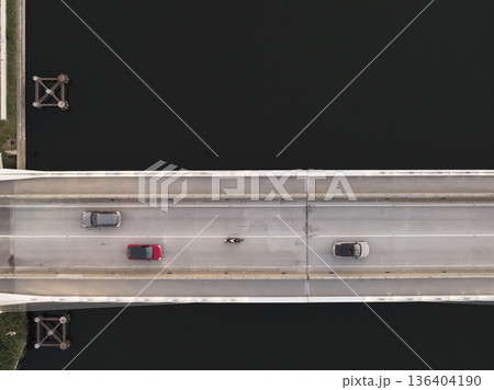 Birds view captures a cars crossing a bridge over a canal Birds view captures a cars crossing a bridge over a canal 136404190