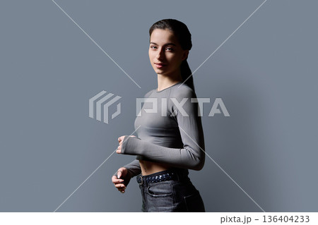 Portrait of beautiful fashionable young woman, 18-19 years old on gray background Portrait of beautiful fashionable young woman, 18-19 years old on gray background 136404233