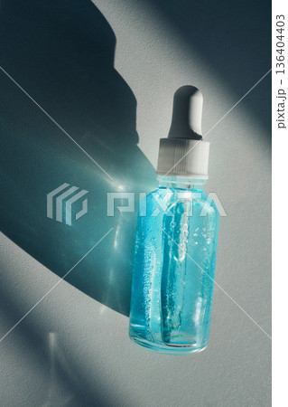 Blue liquid two-phase skincare serum in dropper bottle showing hydration and cosmetic beauty Blue liquid two-phase skincare serum in dropper bottle showing hydration and cosmetic beauty 136404403