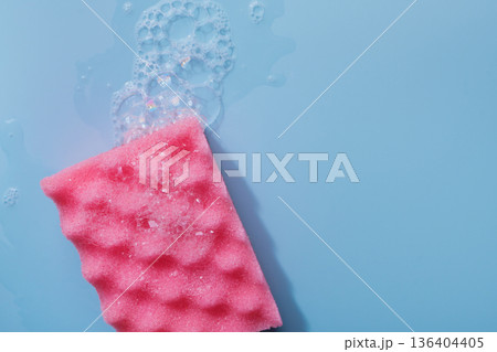 Colorful cleaning sponge with soap bubbles on blue background 136404405