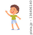 Smiling cartoon boy with curly brown hair, wearing green t-shirt, blue shorts, and slippers, waving hand. Happy child character illustration on white background. Cartoon vector illustration 136406140