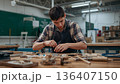 Young Person Works on Wood Project in Workshop During Daylight 136407150