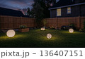 Outdoor Lights Illuminate a Backyard Yard at Night in a Residential Area With Fences and Plants 136407151