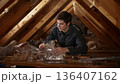 Young Person Works in an Attic on a Project With Tools and Materials During a Weekend 136407162
