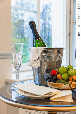 Elegant champagne bottle resting in a frosty ice bucket beside a crystal flute 136407187