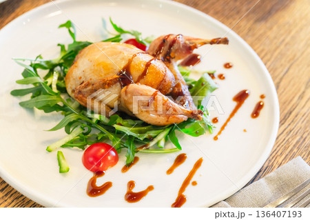Studio food photography of whole baked quail with herbs and vegetable 136407193
