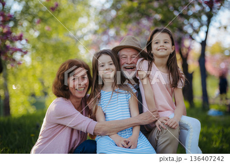 Grandparents spending time with granddaughters in park. 136407242
