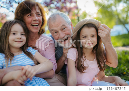 Grandparents spending time with granddaughters in park. 136407245