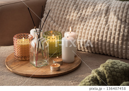 Candles and Reed Diffuser on Wooden Tray. Cozy Home Decor lifestyle with Cushions 136407458