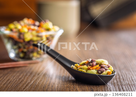 Fresh salad with edamame beans in ceramic spoon on wooden table. 136408211