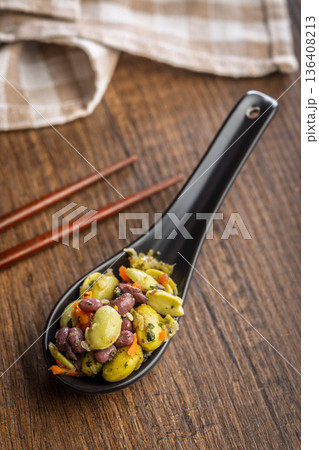 Fresh salad with edamame beans in ceramic spoon on wooden table. Fresh salad with edamame beans in ceramic spoon on wooden table. 136408213