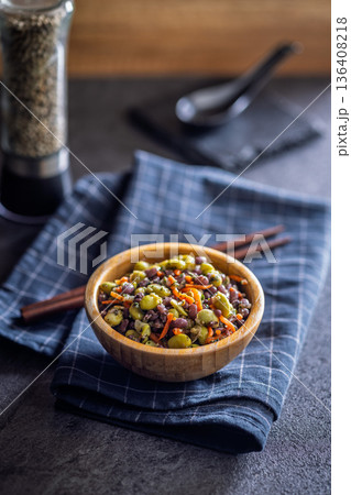 Fresh salad with edamame beans in bowl on black table. 136408218