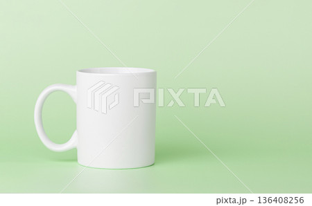 white cup for tea or coffee on a green background white cup for tea or coffee on a green background 136408256