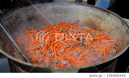Chef prepares sweet carrots, Gourmet cook garnishes glazed vegetables, Culinary artist finishes glazed carrot topping expertly, Skilled chef decorates with caramelized carrot strips amidst lively Chef prepares sweet carrots, Gourmet cook garnishes glazed vegetables, Culinary artist finishes glazed carrot topping expertly, Skilled chef decorates with caramelized carrot strips amidst lively 136408542