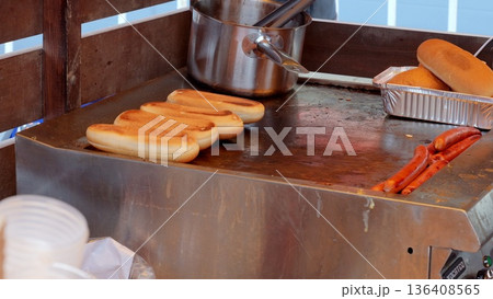 Street vendor preparing spicy sausage sandwiches, Crowded food stall serving freshly grilled hotdogs and sausages, Vibrant festival atmosphere with sizzling sausage wraps and steaming buns freshly Street vendor preparing spicy sausage sandwiches, Crowded food stall serving freshly grilled hotdogs and sausages, Vibrant festival atmosphere with sizzling sausage wraps and steaming buns freshly 136408565