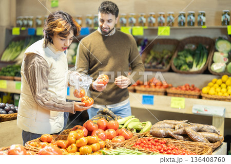 Young couple choose tomatoes in store in store 136408760