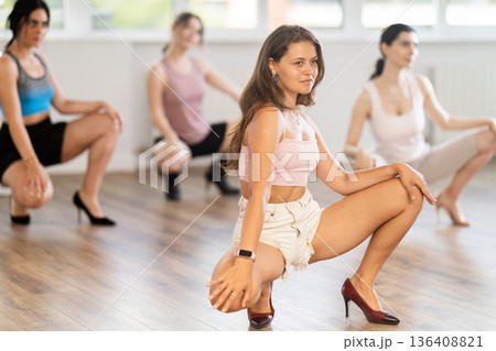 Expressive young girl partaking in group sass dance class 136408821