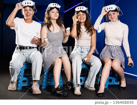 Cheerful young girls anticipating virtual reality game experience Cheerful young girls anticipating virtual reality game experience 136408850