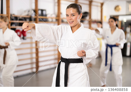 Women students repeat position and perform sequence of punches and painful techniques kata 136408858