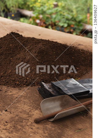 Close up of soil and organic compost mix on a wooden surface, ready for filling seedling bags 136409627