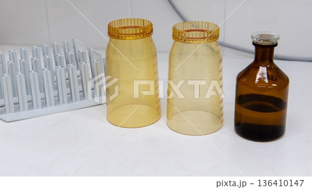 Plastic laboratory funnels for water filtration, amber glass bottle and tubes racks on workbench Plastic laboratory funnels for water filtration, amber glass bottle and tubes racks on workbench 136410147