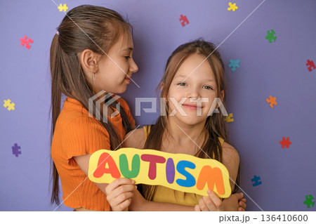 A girl hugs her sister with an autism spectrum disorder. World Autism Awareness Day. Support and care for loved ones A girl hugs her sister with an autism spectrum disorder. World Autism Awareness Day. Support and care for loved ones 136410600