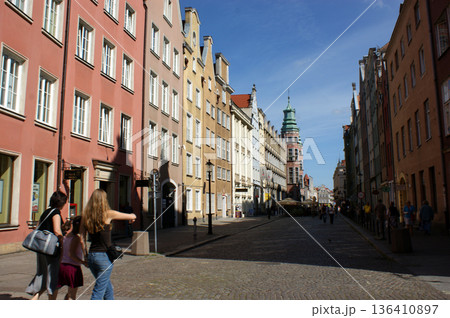 Old town square buildings lit by the sun in a row, people in the market square Poland Old town square buildings lit by the sun in a row, people in the market square Poland 136410897