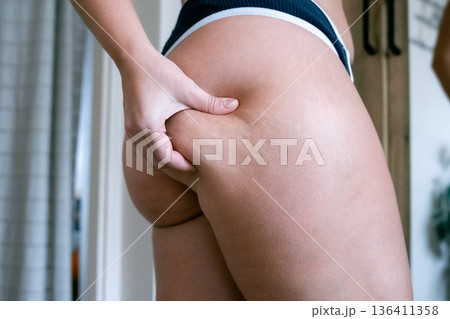 Woman weight check. Female examining torso fat indoors. Self car Woman weight check. Female examining torso fat indoors. Self car 136411358