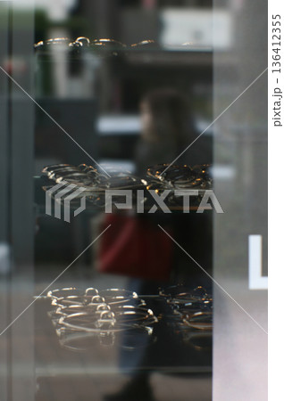 眼鏡店の窓と女性歩行者（ソフトフォーカス） 136412355