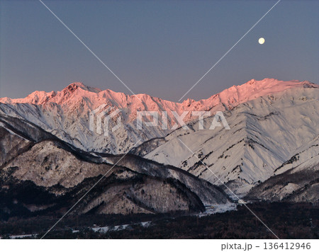 美しい唐松岳・五竜岳のモルゲンロートと沈みゆく十六夜の月　長野県白馬村（ドローンによる空撮） 136412946