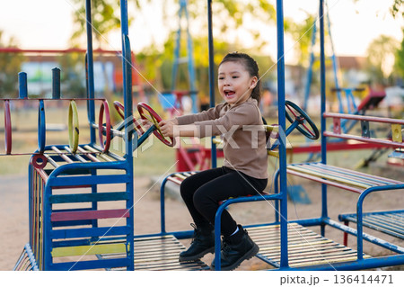 child girl playing with a steering wheel toy on playground child girl playing with a steering wheel toy on playground 136414471