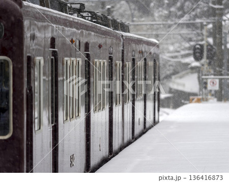 雪が積もった駅に停車する電車 136416873