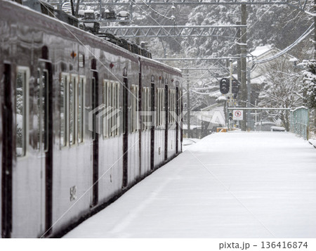 雪が積もった駅に停車する電車 136416874
