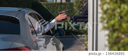 Hand Man in car receiving coffee in drive thru fast food restaurant Hand Man in car receiving coffee in drive thru fast food restaurant 136416891