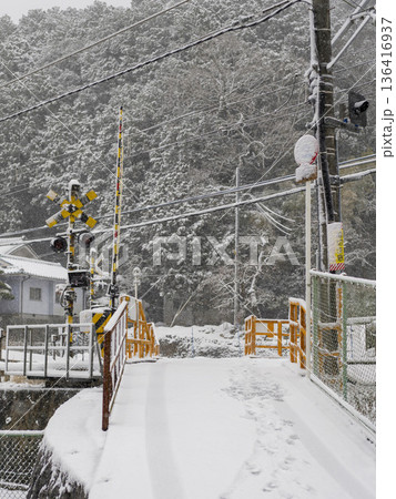 雪が積もる能勢電鉄妙見線の踏切 136416937