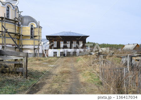 A residential wooden monastery building next to a church under construction in Siberia, Russia A residential wooden monastery building next to a church under construction in Siberia, Russia 136417034