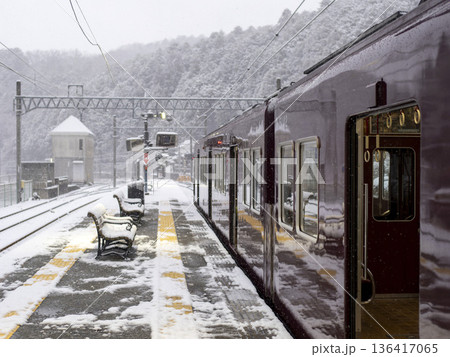 雪が積もった駅に停車する能勢電鉄の電車 136417065