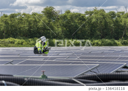 Engineer Checking and working setup Floating solar panels or solar cell Platform system on the lake. Engineer Checking and working setup Floating solar panels or solar cell Platform system on the lake. 136418118