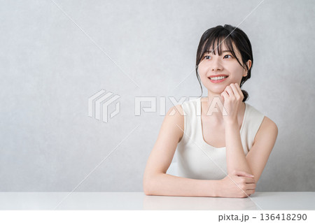 頬杖をつく美肌の笑顔のアジア人女性（美容・エステ・スキンケアイメージ） 136418290
