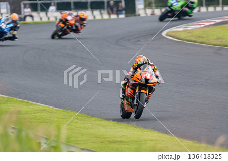 先頭を走るバイクレーサーと追走するマシン・サーキットのレースシーン 136418325