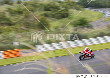 流し撮りで捉えたサーキットを疾走するバイクレーサー・スピード感あるレースシーン 136418327