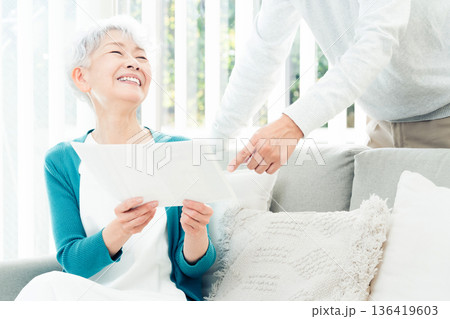 ソファで書類を見るシニア女性 136419603