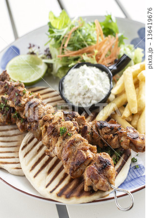 BBQ chicken skewer gyros plate on white table in mykonos restaurant greece BBQ chicken skewer gyros plate on white table in mykonos restaurant greece 136419676
