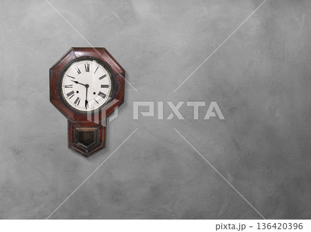 An old wall clock on a cement wall. An old wall clock on a cement wall. 136420396
