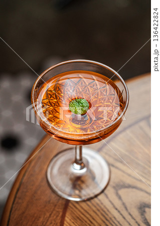 Amber cocktail in coupe glass with garnish Amber cocktail in coupe glass with garnish 136422824