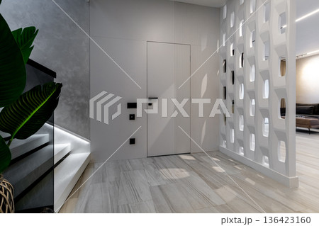 Modern hallway with geometric partition and illuminated stairs Modern hallway with geometric partition and illuminated stairs 136423160